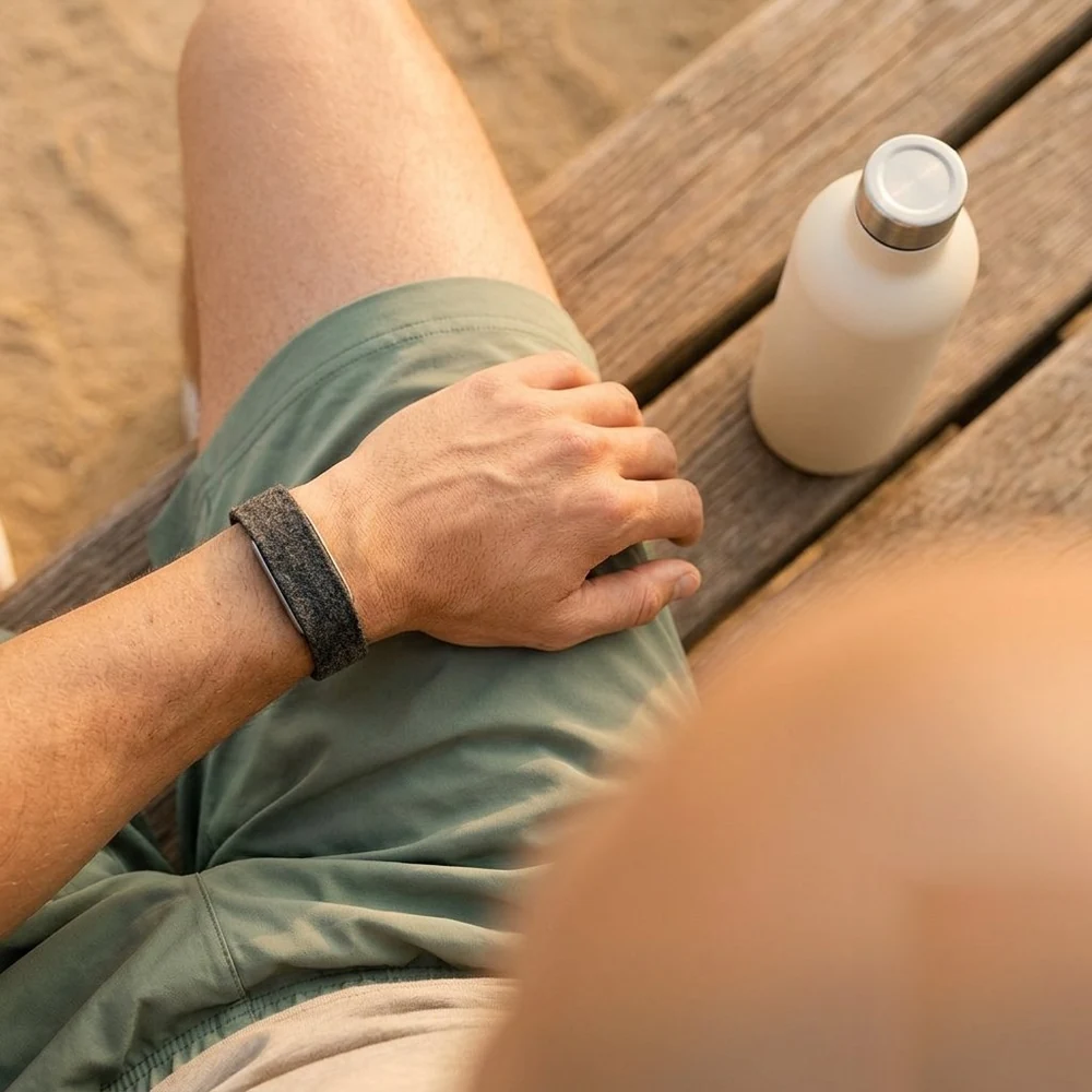 The Hume Band 2.0 worn by a runner during post-workout recovery on a park bench